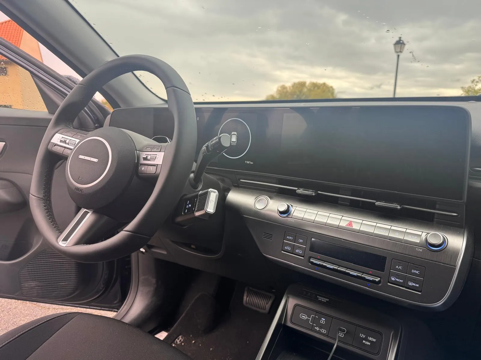 Interior del Hyundai KONA XLS con volante de cuero, dos pantallas de 12,3 pulgadas y mandos físicos del climatizador bizona