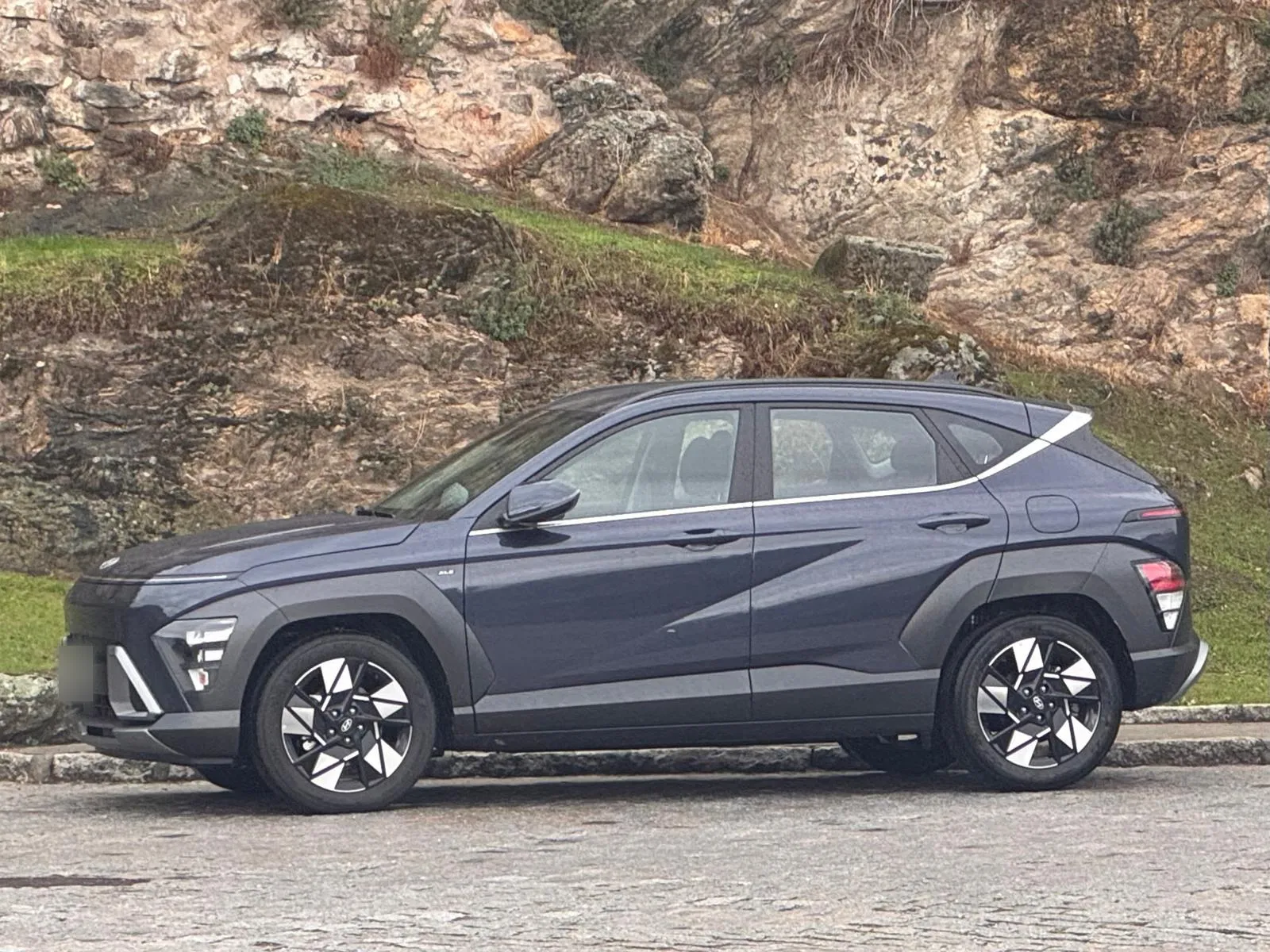 Perfil lateral del Hyundai KONA XLS Denim Blue con llantas bitono de 18 pulgadas y línea de cintura cromada