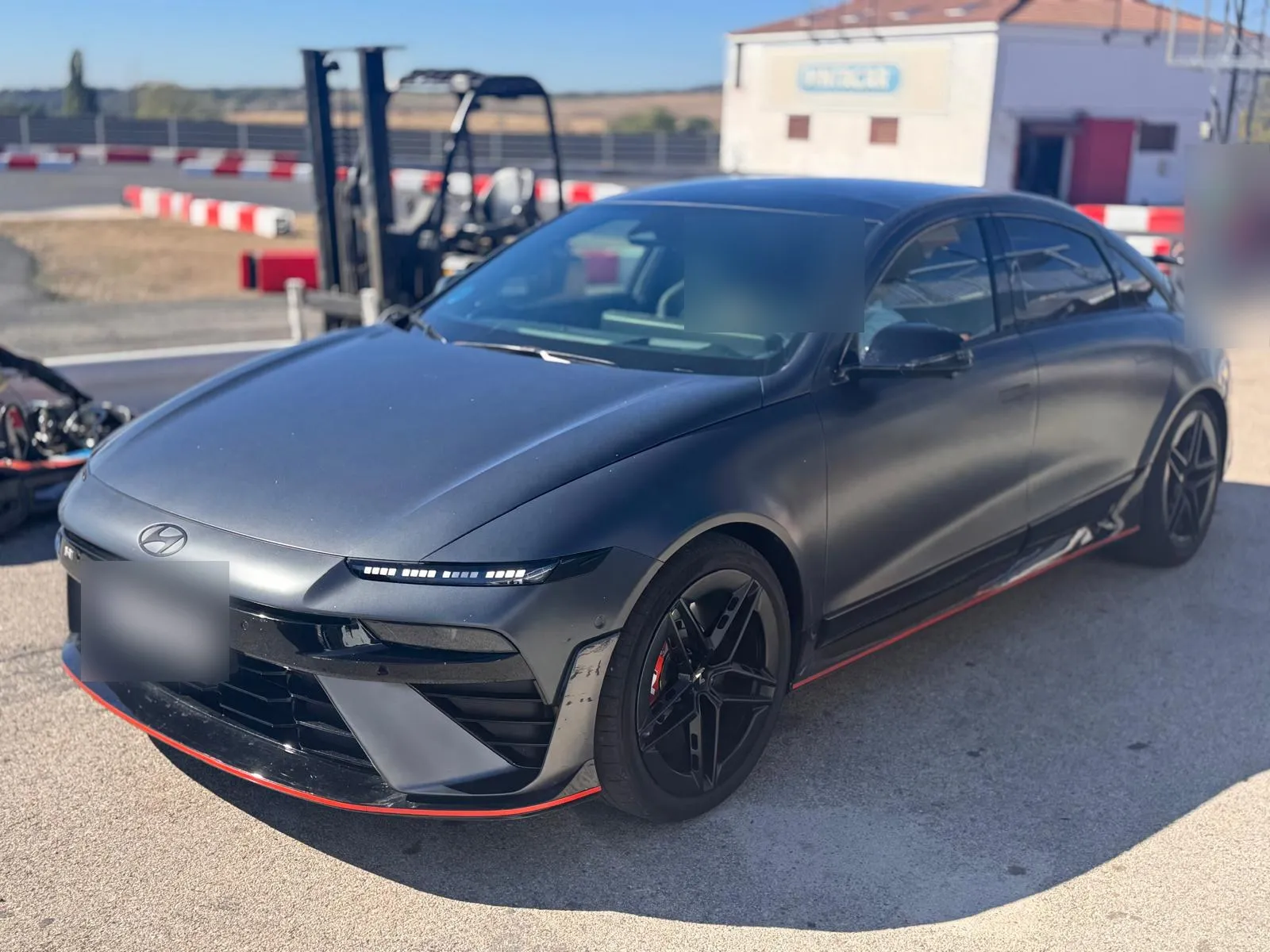 Hyundai IONIQ 6 N gris oscuro mate visto de tres cuartos delantero con faldón rojo y llantas negras