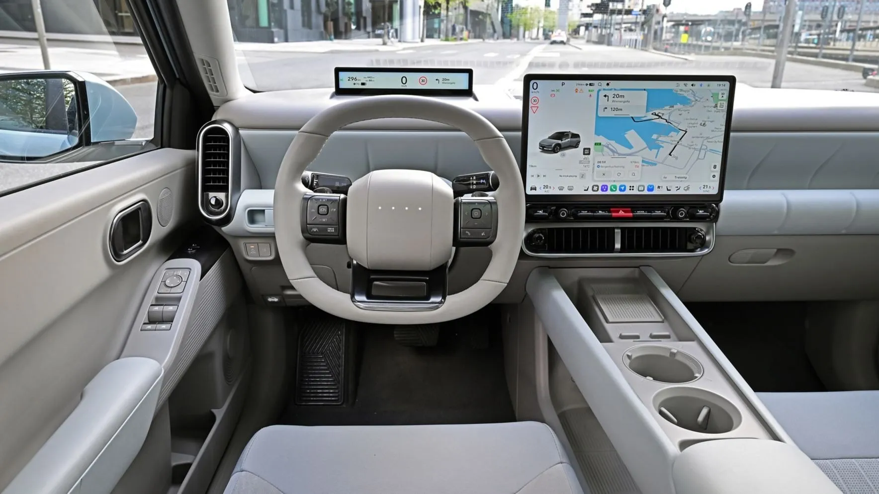 Interior del Hyundai IONIQ 3 con la pantalla central de Pleos Connect, la pantalla fina del conductor y el volante