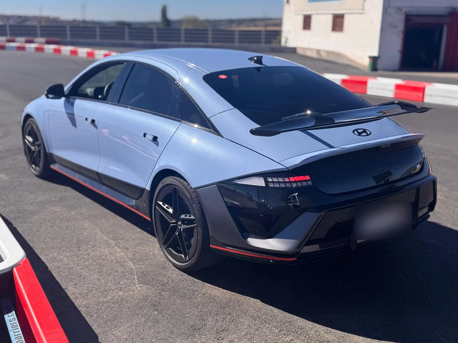 Hyundai IONIQ 6 N azul visto de tres cuartos trasero con el gran alerón de cuello de cisne y el difusor