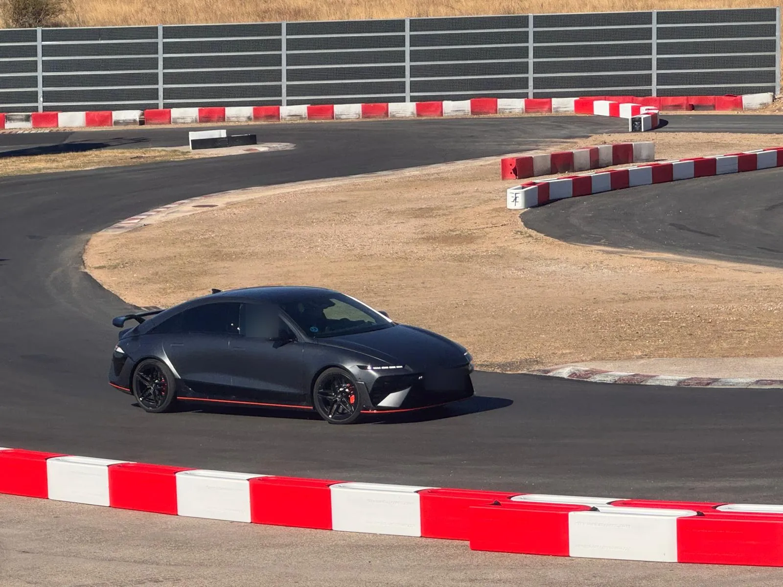 Hyundai IONIQ 6 N gris oscuro mate trazando una curva en circuito
