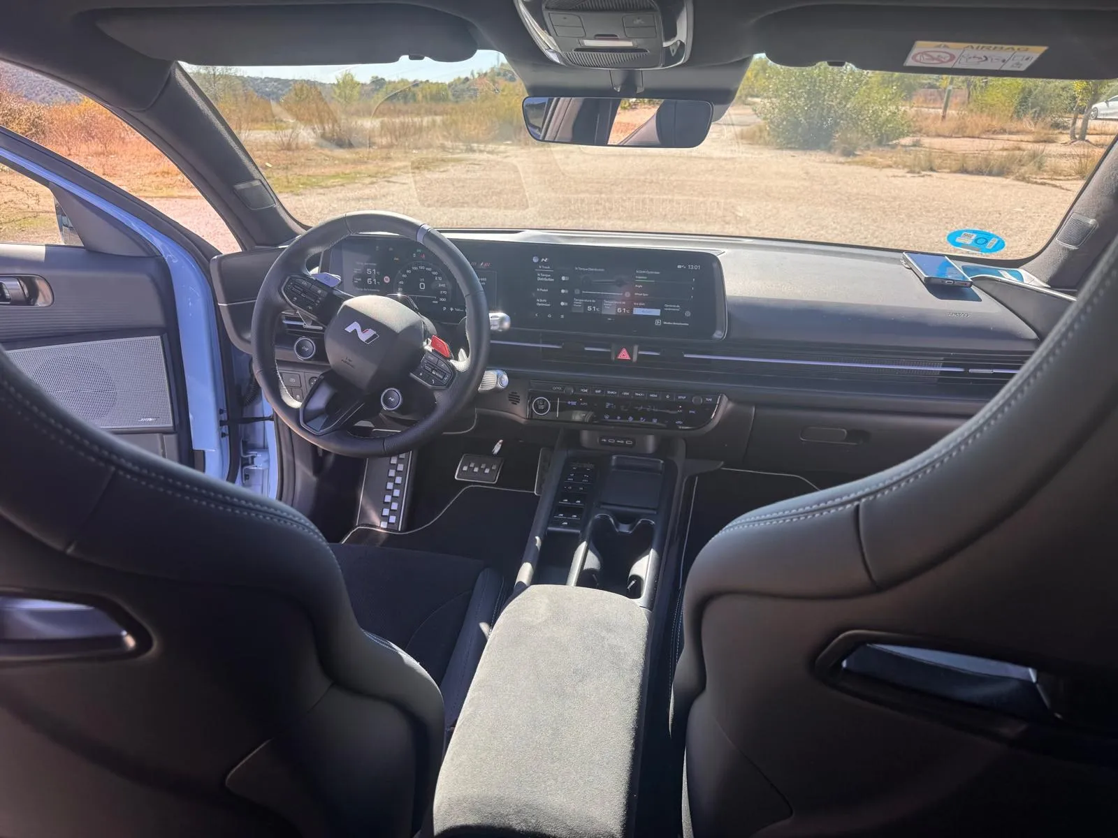 Interior del Hyundai IONIQ 6 N visto desde atrás con dos baquets de alcántara, consola central y salpicadero