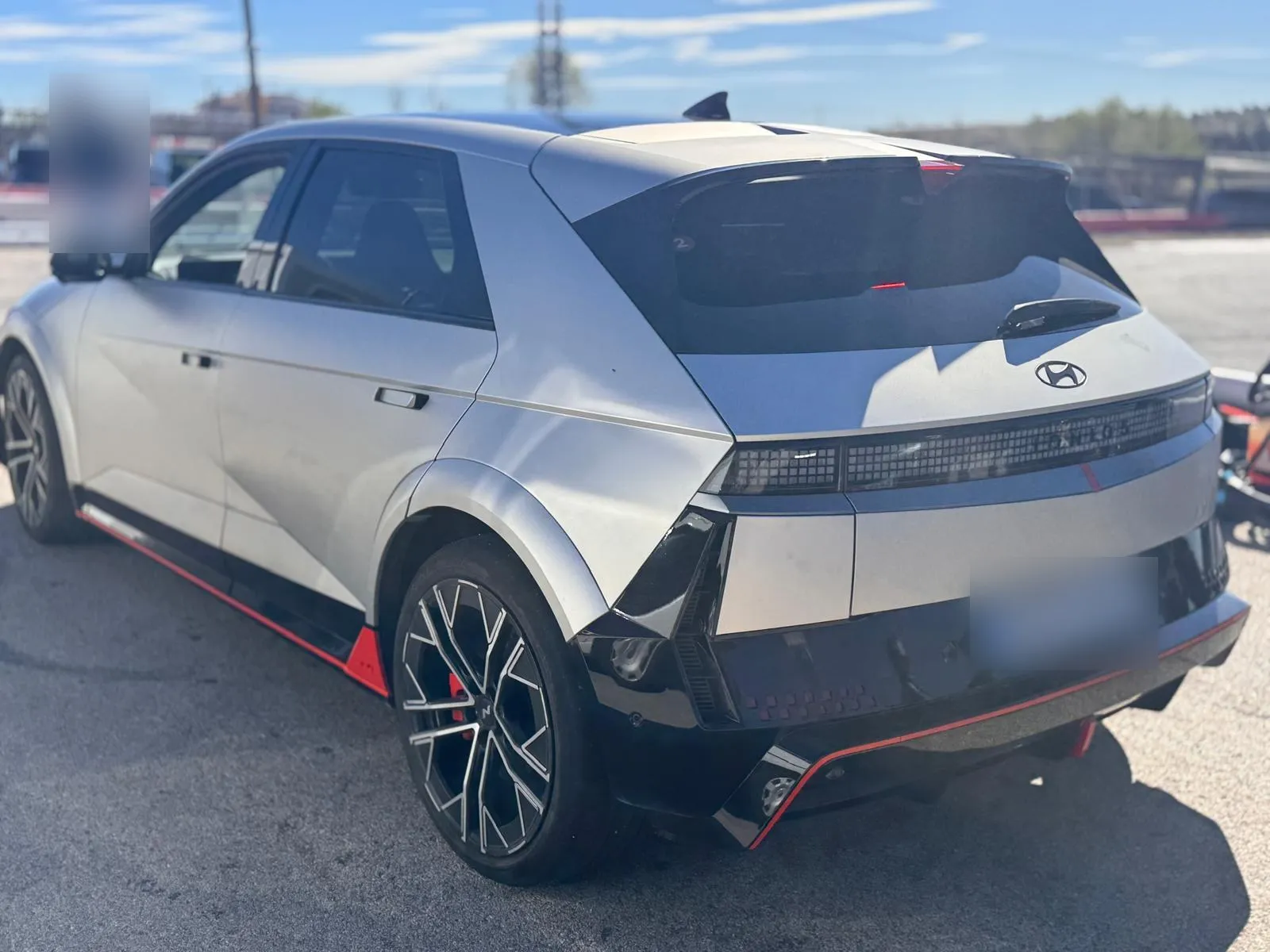 Hyundai IONIQ 5 N gris visto de tres cuartos trasero con alerón, difusor negro y filo rojo