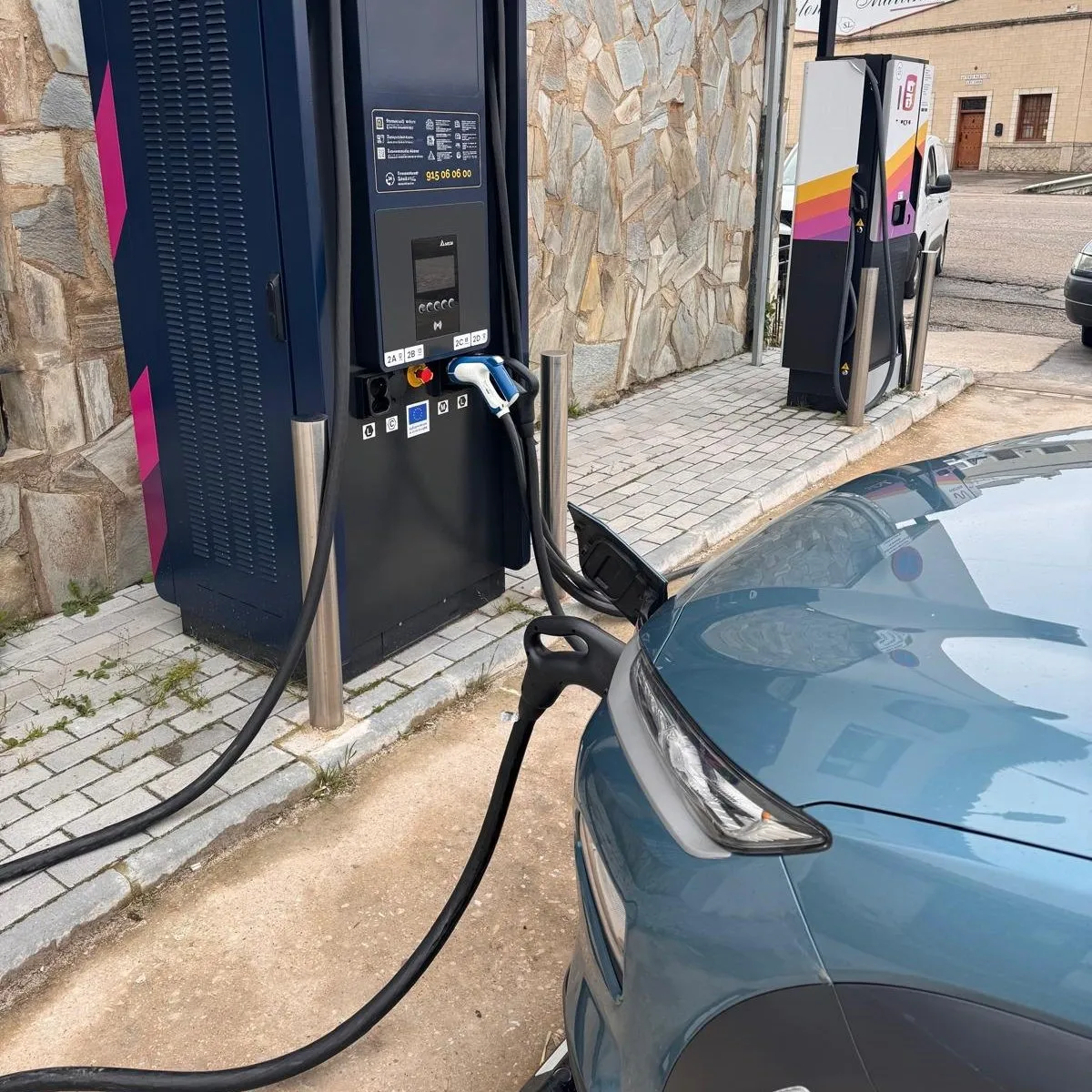 Hyundai KONA Eléctrico conectado a un cargador rápido en una calle de un pueblo