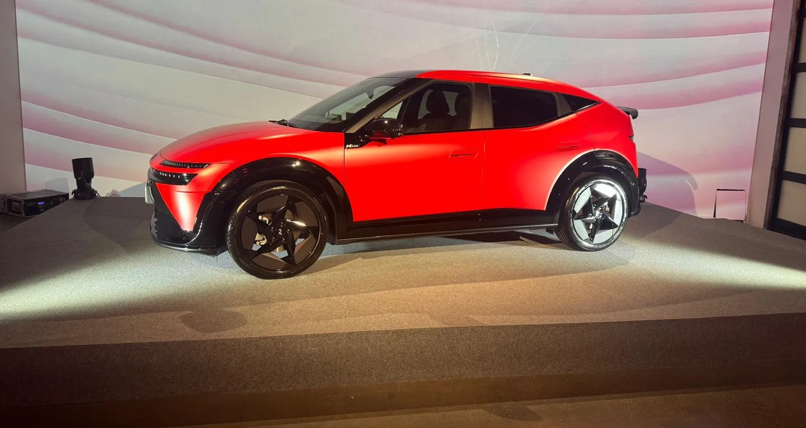 Perfil lateral del Hyundai IONIQ 3 N Line rojo con pasos de rueda negros y llantas de diseño en estrella